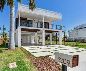 Salt Cove Front Elevation With Walkway | Seasafe Homes Elevated coastal home with open ground level built for flood protection and 180 mph wind resistance